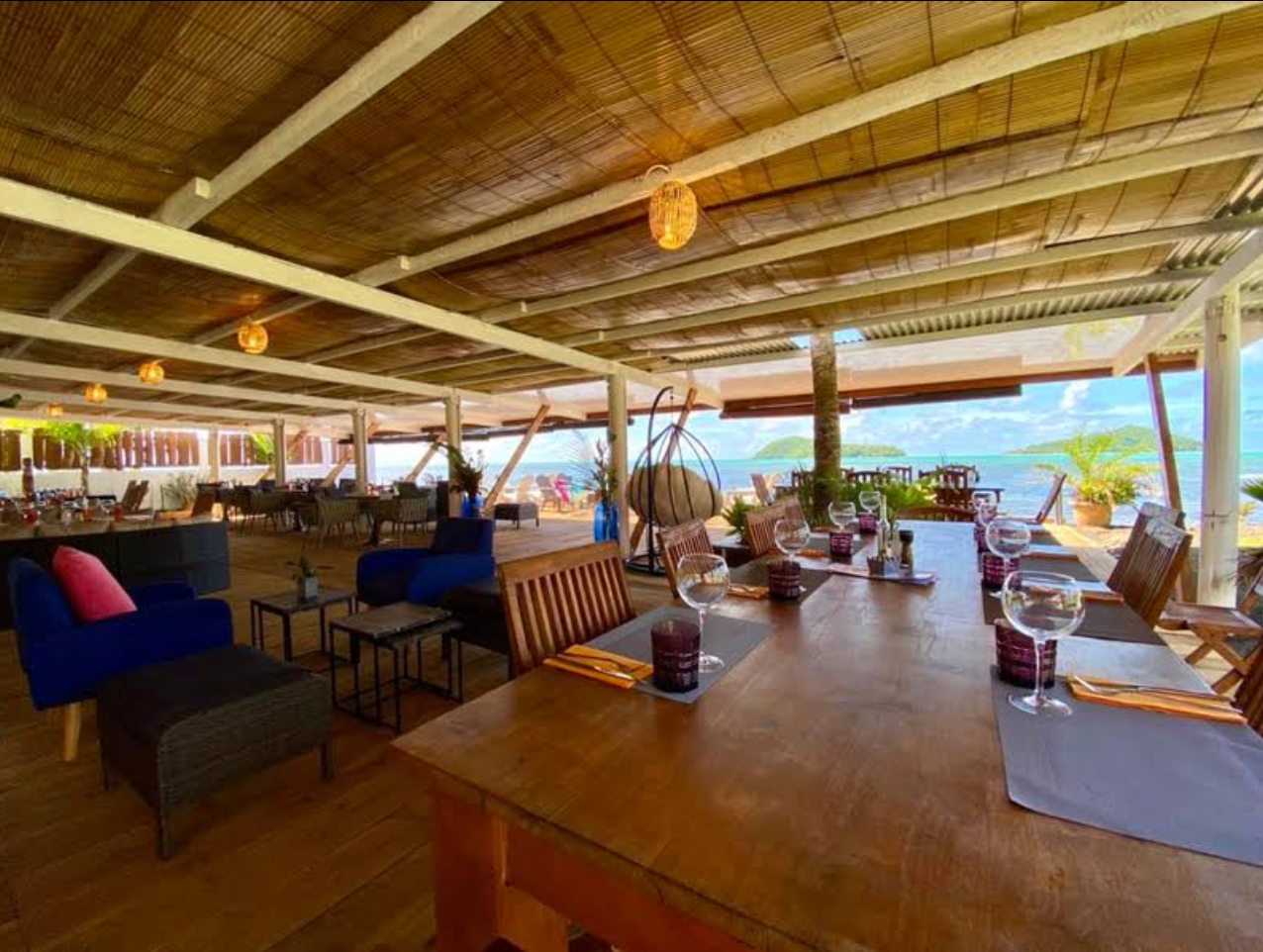 Salle lounge en bois du Beach Club ouverte sur le lagon